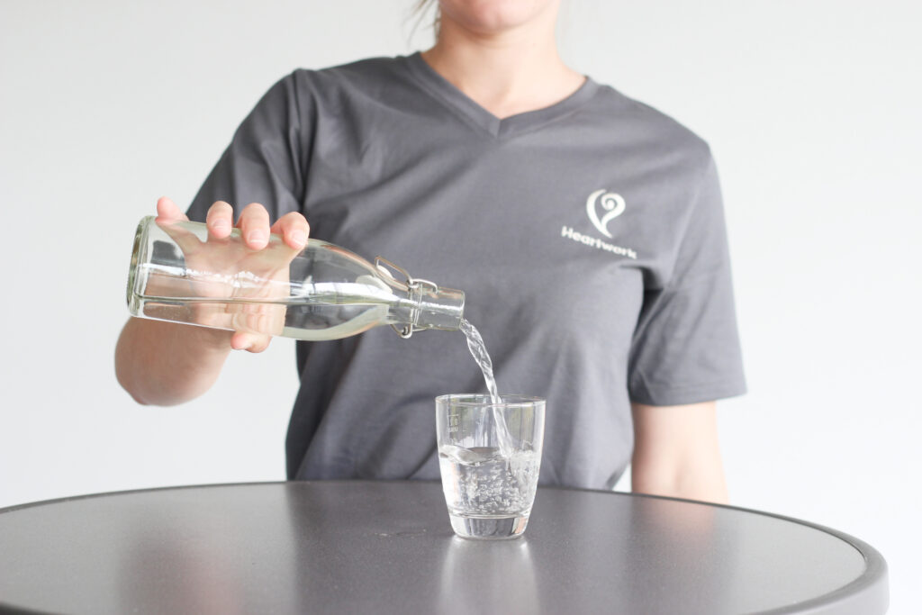 Frau füllt Wasser in Glas